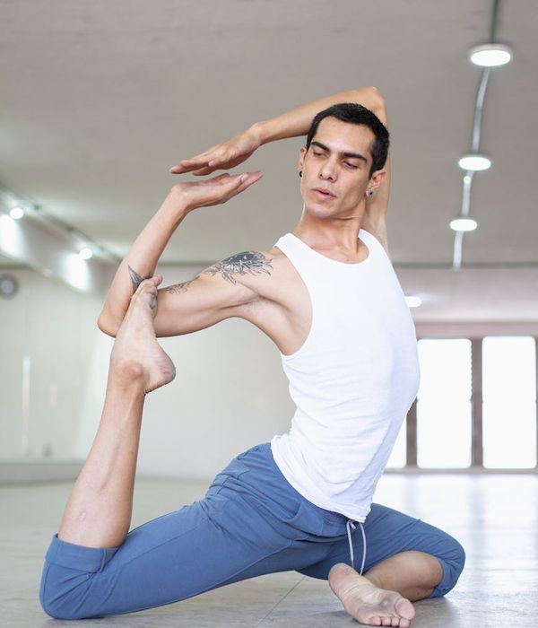 Man performing a controlled strength exercise in a dark, minimalist setting.